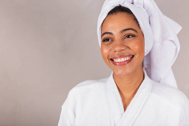 beautiful Brazilian black woman, wearing bathrobe and towel. Close-up photo, smiling, teeth, well being. - Fotografie, Obrázek