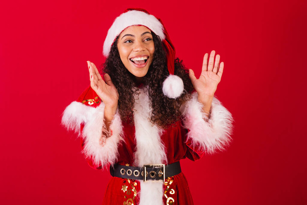 beautiful brazilian black woman, dressed as santa claus, christmas clothes. surprise, astonished, fright, very happy. - Photo, Image