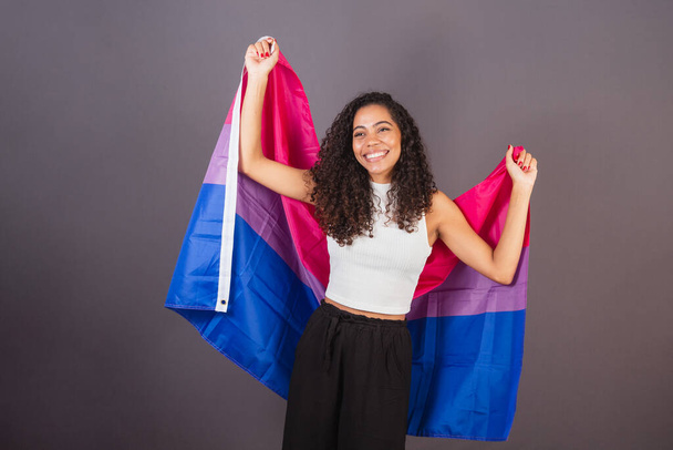 Young Brazilian black woman raising bisexual flag, Bisexual woman, LGBT, LGBTQ - Foto, Bild