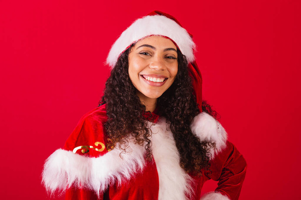 beautiful brazilian black woman, dressed as santa claus, christmas clothes. smiling, close-up photo, looking at camera. - Valokuva, kuva
