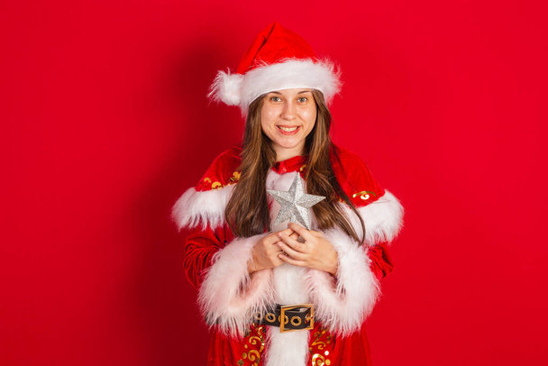 Caucasian, Brazilian woman in Christmas clothes, Santa Claus. Holding christmas star. - Fotó, kép
