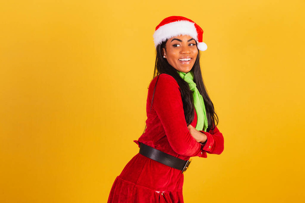 Beautiful black Brazilian woman, dressed in Christmas clothes, Santa Claus, arms crossed. - Foto, Imagem