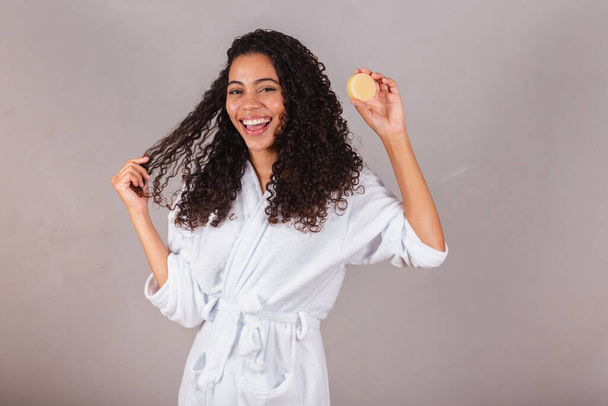 Brazilian black woman, wearing bathrobe and towel. vegan products for beauty and skin and hair care. soaps, Spa, self care. welfare. - Fotó, kép
