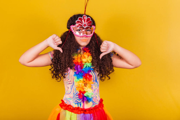 caucasian, brazilian girl dressed for carnival. thumb down, disapproval, negative, sad - Фото, зображення