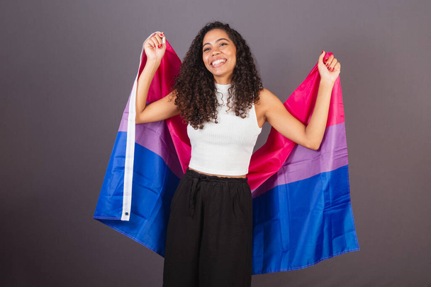 Young Brazilian black woman raising bisexual flag, Bisexual woman, LGBT, LGBTQ - Photo, Image