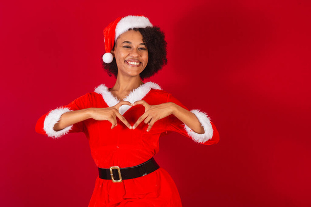 beautiful black brazilian woman, dressed as santa claus, mama claus, heart sign with hands - Фото, изображение