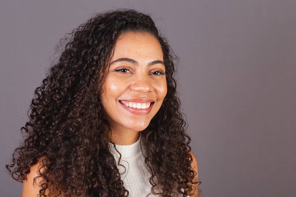 Young Brazilian black woman, close-up photo, smiling looking at camera, white teeth, smile. - Foto, Imagem
