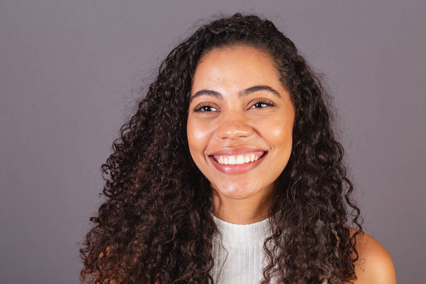 Young Brazilian black woman, close-up photo, smiling looking at camera, white teeth, smile. - Foto, Imagen