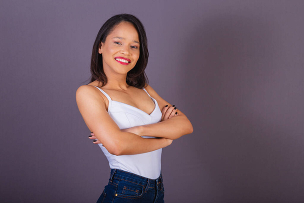 young adult woman from northeastern brazil. crossed arms. confident and smiling. - 写真・画像