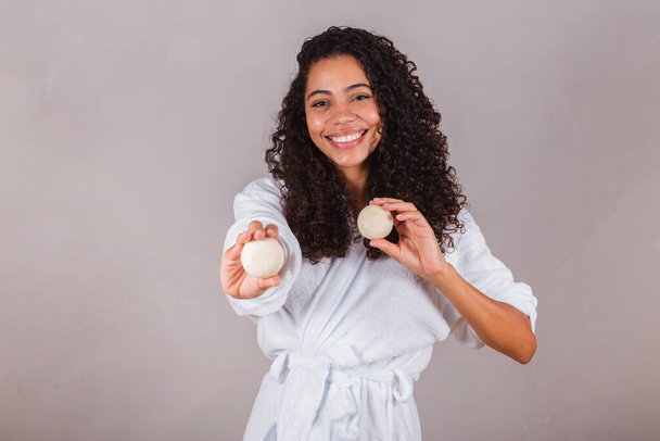 Brazilian black woman, wearing bathrobe and towel. vegan products for beauty and skin and hair care. soaps, Spa, self care. welfare. - Foto, afbeelding