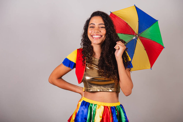 Beautiful black Brazilian woman, with frevo outfit, and umbrella, carnival. - Photo, image
