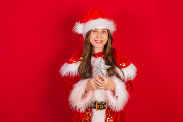 Caucasian, Brazilian woman in Christmas clothes, Santa Claus. Holding christmas star. - Фото, изображение