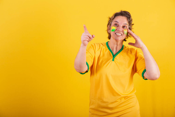adult adult woman, brazil soccer fan, pointing something in the distance, publicity photo. - Foto, imagen