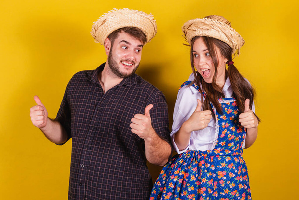 Beautiful couple wearing typical clothes for the Festa Junina. Thumb, positive, affirmative. approval. - Φωτογραφία, εικόνα