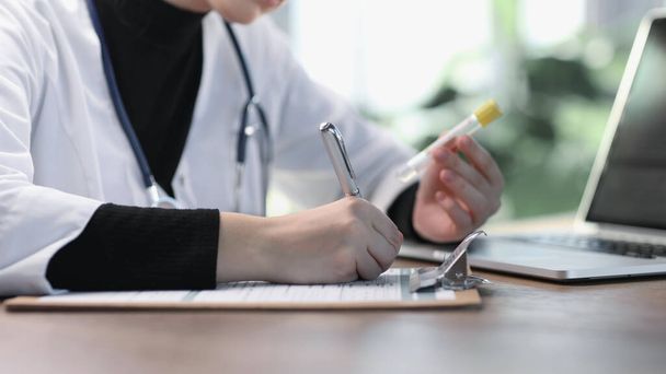 Female professional doctor hand making notes in medical journal. - Foto, immagini