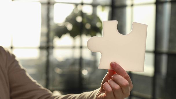 Business Woman holding two blank white puzzle pieces in his hands conceptual of solving a problem - Foto, Imagen