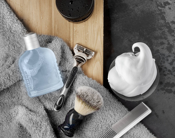 Acessórios de barbear com espuma de barbear, navalha, escova de barbear, loção em fundo preto. Deitado plano, vista superior - Foto, Imagem