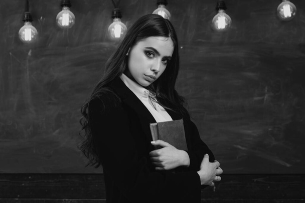 Portrait of girl teenager in school. Young teenager with school books. Back to school. Beautiful female holding her books in auditorium. Back to school and happy time - Foto, Bild