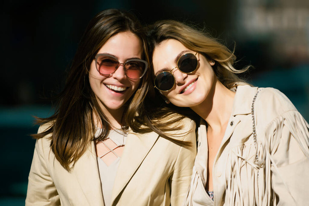 Portret van twee vrouwen, lachende meisjes vrienden in een zonnebril buiten - Foto, afbeelding