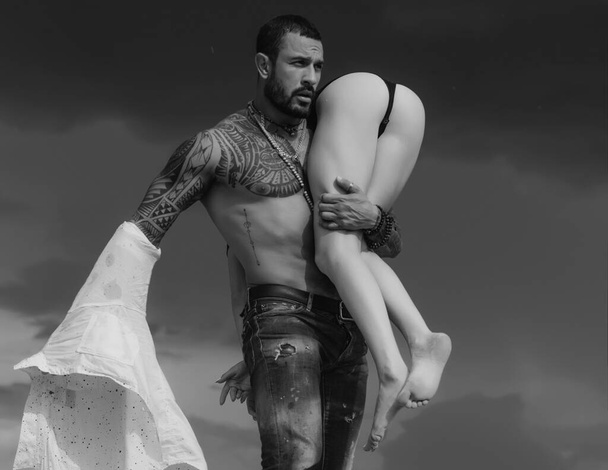 Latino handsome man and sexy woman. Man is carrying his woman. Love. Couple. Passion - 写真・画像