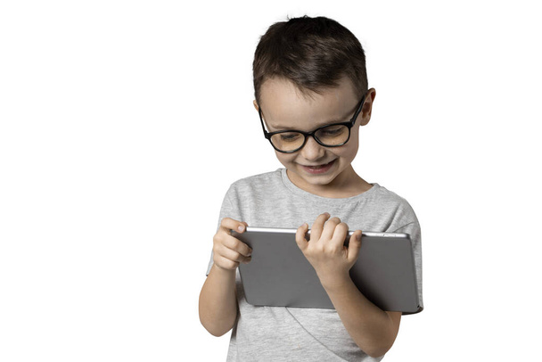 Happy child boy holding a tablet on white background - Fotoğraf, Görsel