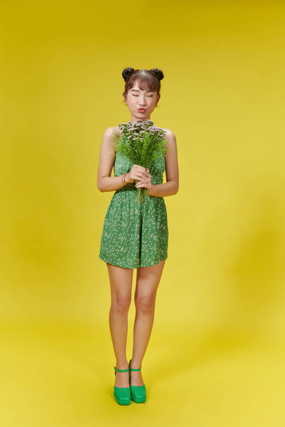 Smiling young woman holding floral bouquet - 写真・画像
