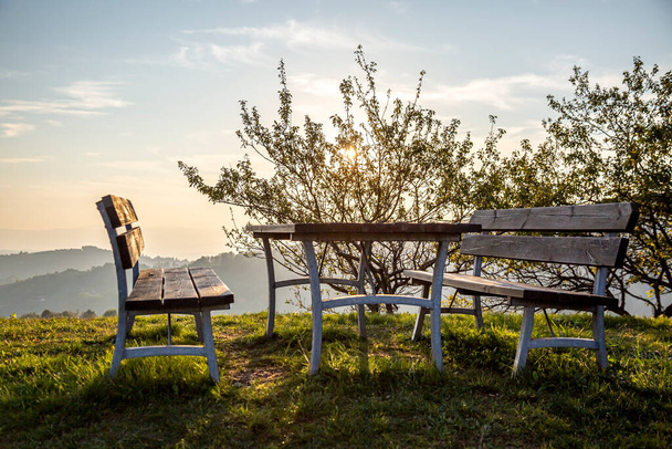 Fa piknik asztal padokkal gyönyörű zöld gyepen csendes helyen, nagyszerű kilátással. - Fotó, kép