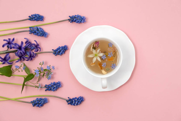 Tea Time: Relaxing with herbal tea with healing properties. Drink with natural herbs. Floral tea arrangement. Nature's remedy aromatic herbal tea with healing herbs and flowers top view vertical - Photo, Image