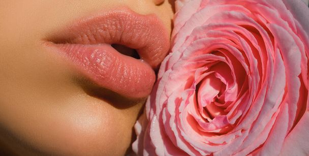 Beautiful woman lips with rose. Close-up sexy woman natural lips and beautiful red rose - Photo, Image