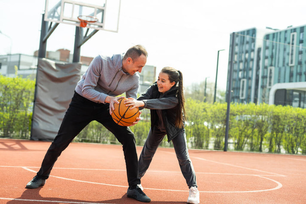 father and daughter playing basketball in the street. - Fotoğraf, Görsel