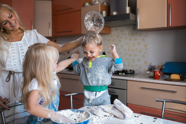 Niños con madre en la cocina
 - Foto, imagen