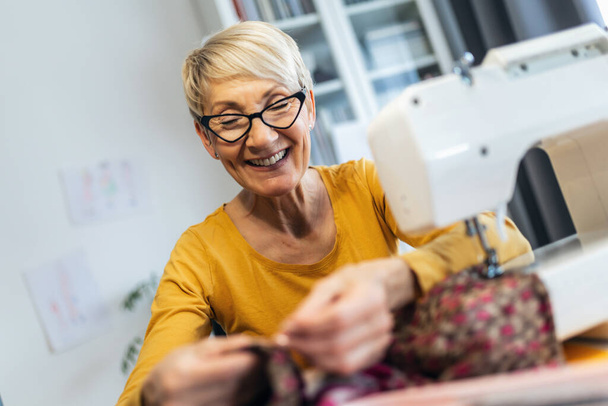 Senior woman sewing at home. Startup small business designer, service. - Photo, Image