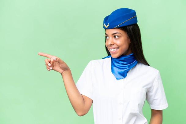 Repülőgép stewardess afro-amerikai nő elszigetelt háttér mutató ujját oldalra, és bemutatja a termék - Fotó, kép