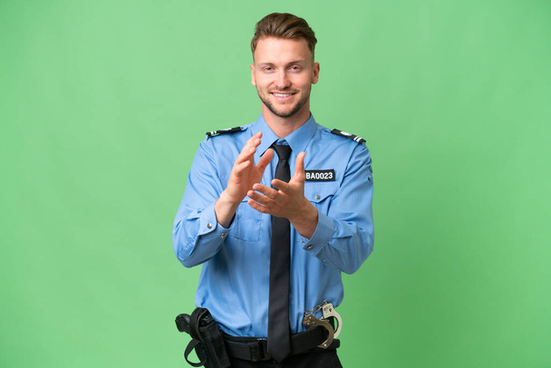 Mladý policista přes izolované pozadí aplauding po prezentaci v konferenci - Fotografie, Obrázek