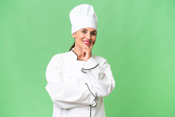 Middle-aged chef woman over isolated background smiling - Photo, Image