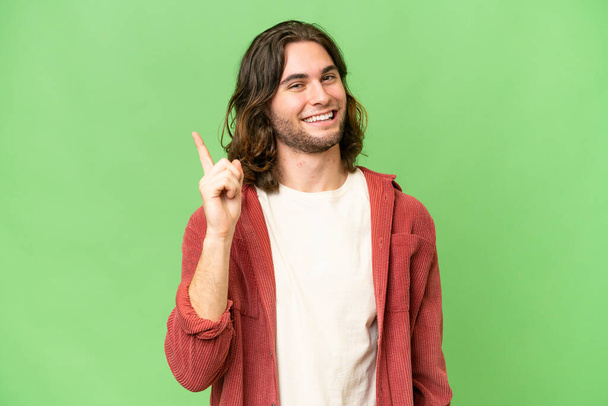 Young handsome man over isolated background showing and lifting a finger in sign of the best - Photo, Image