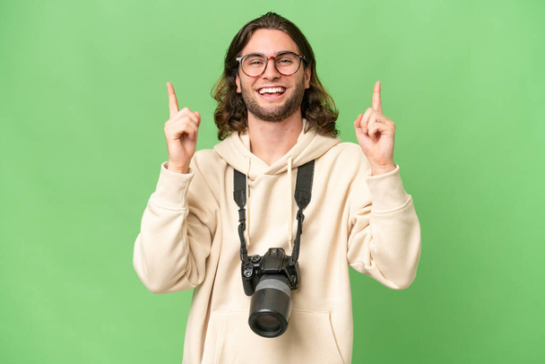 Young photographer man over isolated background pointing up a great idea - Photo, Image