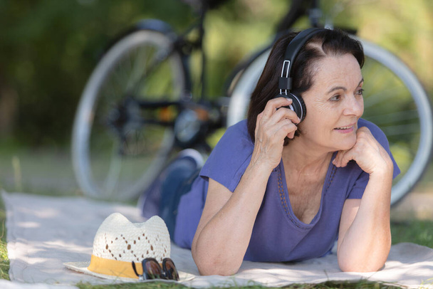 mature woman listening to the music on headphones - Foto, afbeelding