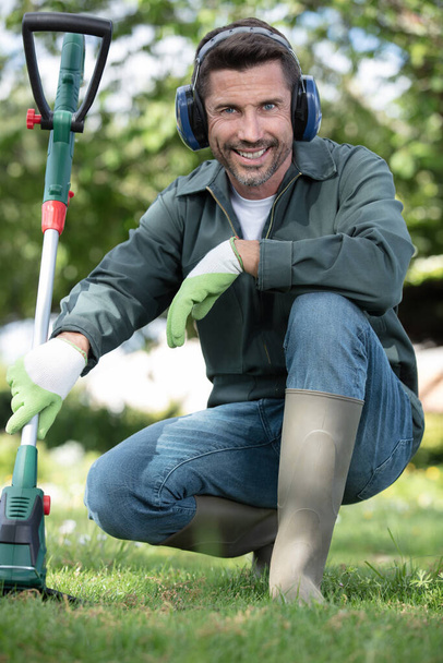 portrait of a male gardener with a strimmer - Φωτογραφία, εικόνα