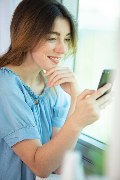 smiling businesswoman using phone in office - Foto, afbeelding