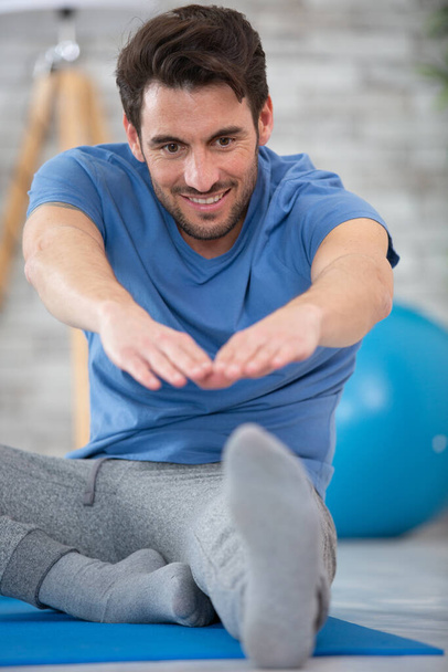 handsome man doing stretch exercise at home - Photo, Image