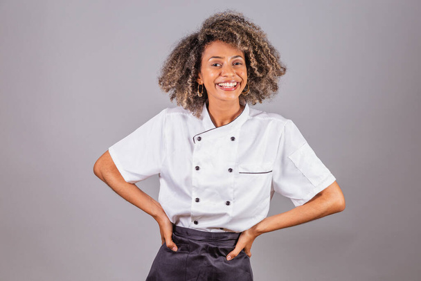Young black Brazilian woman, cook, masterchef, wearing restaurant uniform. Hands on hips. - Φωτογραφία, εικόνα