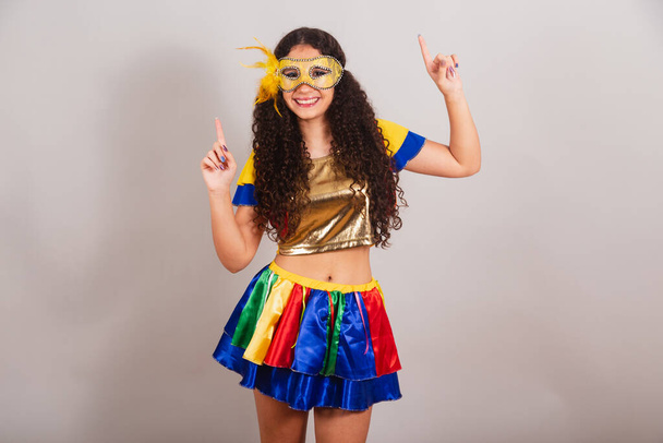 young teen girl, brazilian, with frevo clothes, carnival. mask, dancing. - Foto, imagen