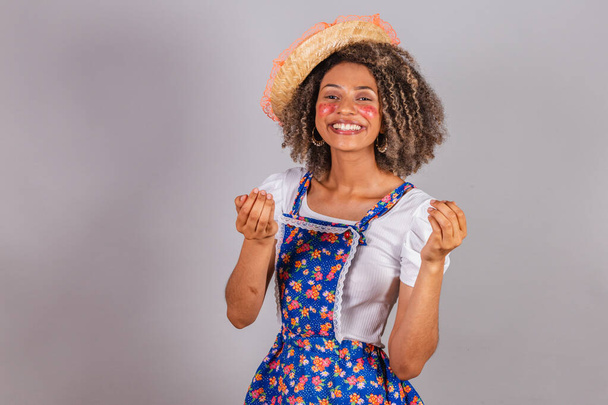 Young black Brazilian woman, with country clothes, dressed for Festa Junina. Saint John's festival. calling with hands, inviting. - Zdjęcie, obraz