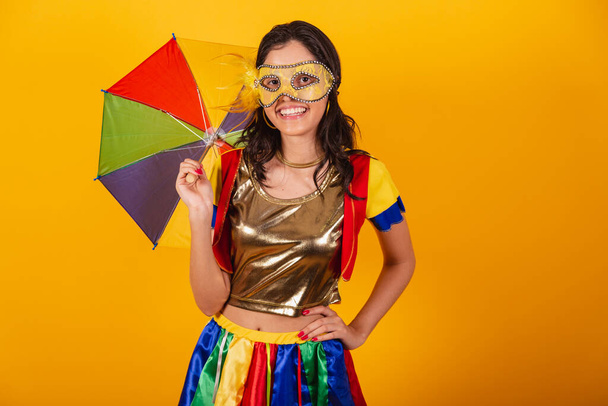beautiful brazilian woman in carnival clothes, with frevo clothes, and colorful umbrella and mask. - 写真・画像