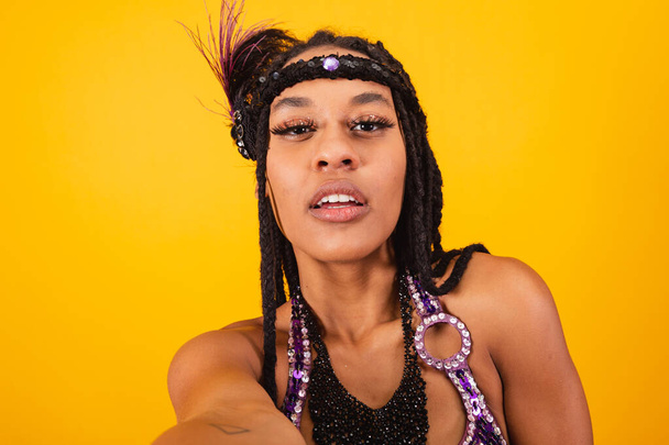 hermosa mujer brasileña negra, en ropa de carnaval púrpura, tomando autorretrato. - Foto, imagen