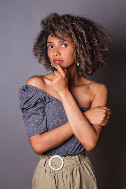 Beautiful black brazilian woman posing on grey studio background  - 写真・画像
