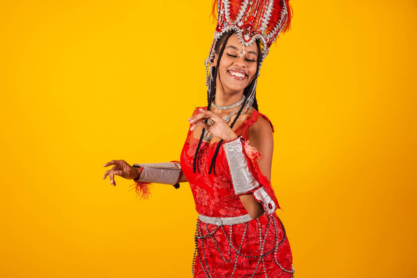 Beautiful black Brazilian woman, with red carnival clothes. dancing, partying. - Foto, Imagen