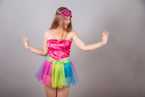 Brazilian blonde woman dressed in pink carnival clothes. wearing mascara, dancing. - Фото, изображение