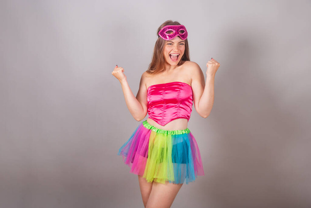 Бразильская блондинка в розовой карнавальной одежде. в маске, празднуя. - Фото, изображение